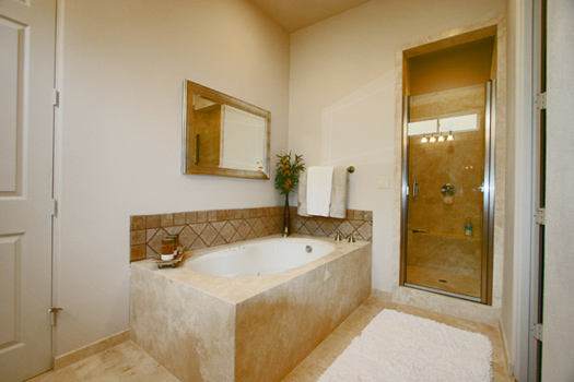 Master bathroom with jetted spa tub and separate shower all finished in slab travertine marble 